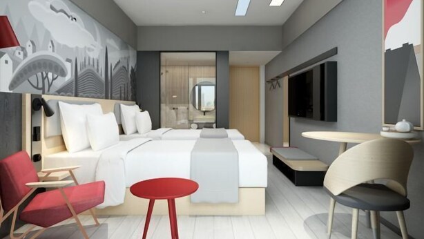 A modern hotel room with a large bed, a desk, a chair, and a TV. - Baibuting Hotel (Haiyan)