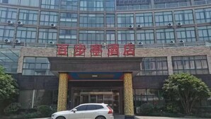 A hotel entrance with a sign reading "Xiaoshe Hotel". - Baibuting Hotel (Haiyan)