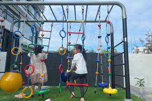 An outdoor play area with a climbing structure and swings. - Xiangshan Jiayi Sisters Holiday Villa (Xiangshan)
