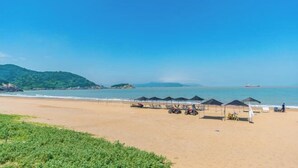 A beach with tents, a boat, and a clear sky. - Xiangshan Jiayi Sisters Holiday Villa (Xiangshan)
