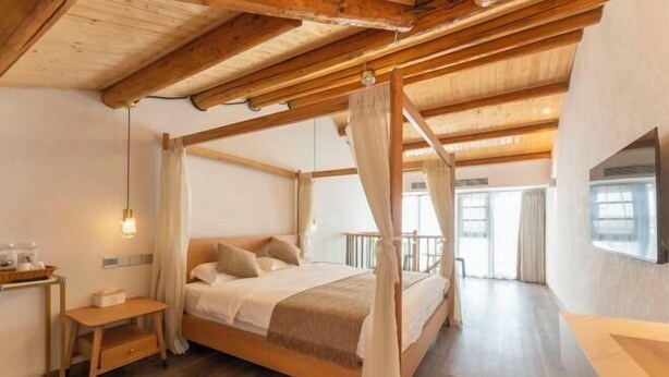 A bedroom with a four-poster bed, wooden beams, a bedside table, a nightstand, and a large window. - Xiangshan Jiayi Sisters Holiday Villa (Xiangshan)