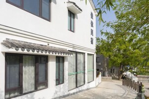 Un edificio de estilo arquitectónico tradicional, con un toldo de tejas y grandes ventanales.