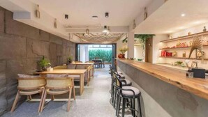 A modern restaurant with a long counter, wooden tables, and chairs. - Xiangshan Jiayi Sisters Holiday Villa (Xiangshan)
