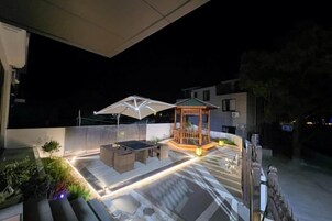 Un espacio al aire libre con patio amoblado, un pabellón y un sendero.