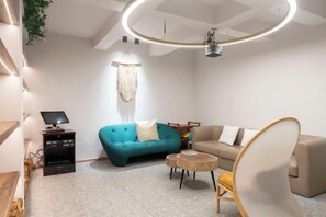 A modern living room with a teal sofa, a beige sofa, a round coffee table, and a unique chair. - Xiangshan Jiayi Sisters Holiday Villa (Xiangshan)