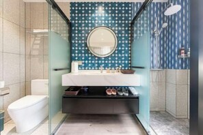 Un bagno moderno con box doccia in vetro, un water bianco e un mobile lavabo con specchio.