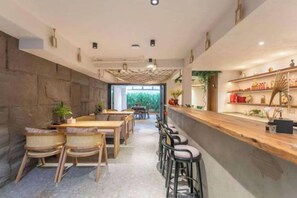 A restaurant interior with a long counter, bar stools, and a seating area with tables and chairs. - Xiangshan Jiayi Sisters Holiday Villa (Xiangshan)