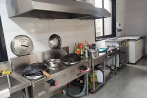 A commercial kitchen with stainless steel appliances, a ventilation hood, and a window. - Xiangshan Jiayi Sisters Holiday Villa (Xiangshan)
