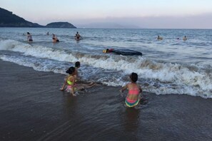 A beach with people in the water and on the shore. - Xiangshan Jiayi Sisters Holiday Villa (Xiangshan)