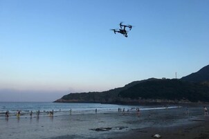 Una playa con un dron volando por encima.