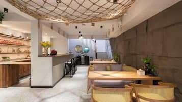 A restaurant interior with a bar area, seating, and a staircase leading to an upper level.