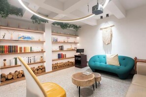 A modern living room with bookshelves, a sofa, and a television. - Xiangshan Jiayi Sisters Holiday Villa (Xiangshan)
