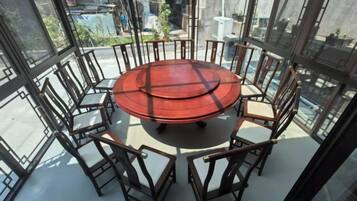 A round table with chairs in a room with large windows.