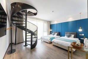Un dormitorio moderno con una escalera espiral, dos camas y una pared de acento azul.