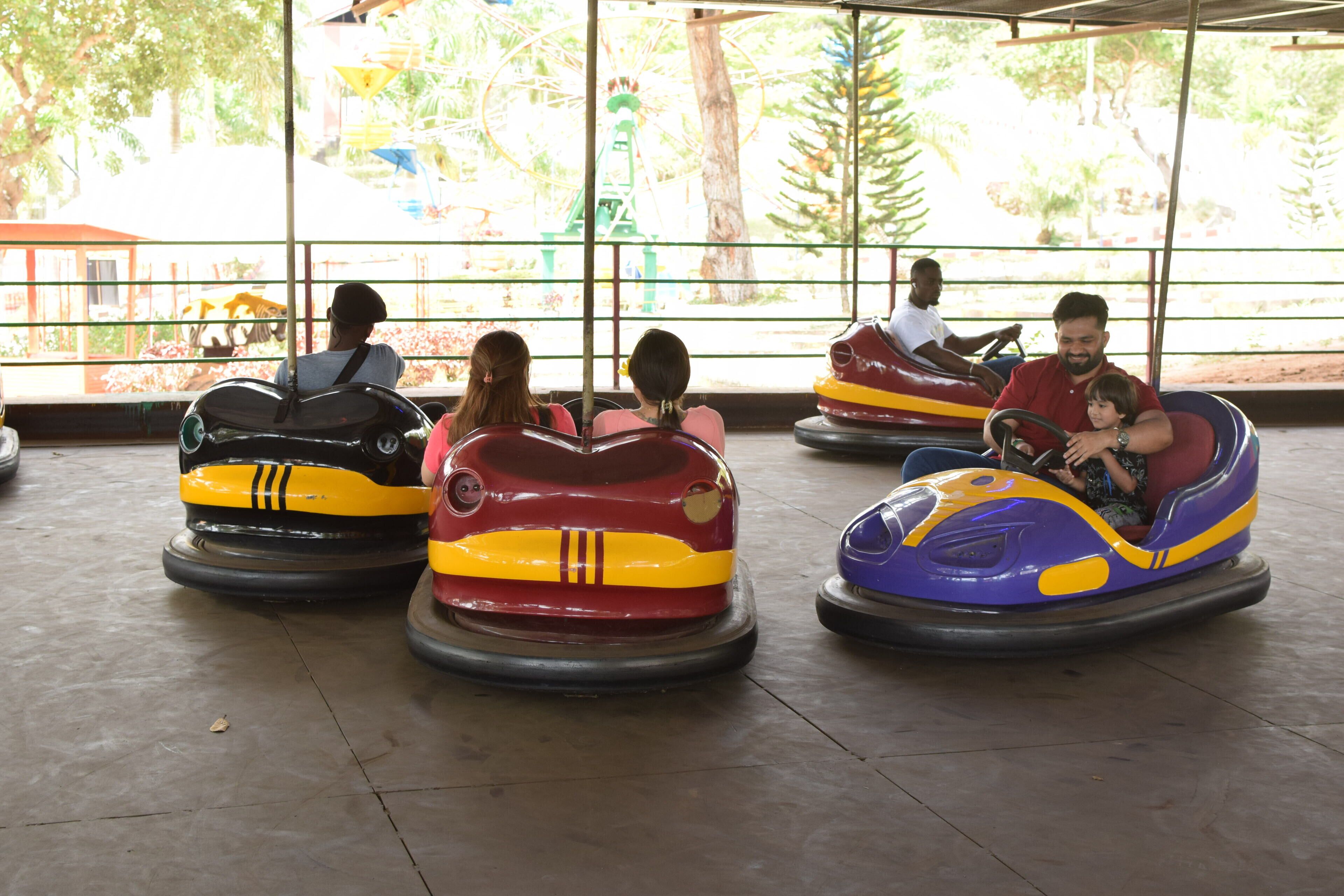 Un paseo en autitos de choque de colores en un parque de atracciones cubierto.