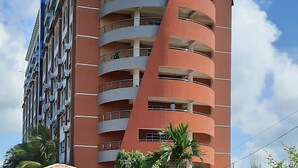 Un immeuble à plusieurs étages doté d’une architecture originale, caractérisé par une façade incurvée et de nombreux balcons.