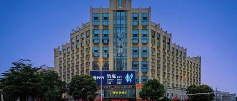 A multi-story building with a symmetrical facade, large windows, and a prominent entrance.