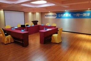 A conference room with a long table, chairs, a podium, and a projection screen. - Yiting Business Hotel (Quanzhou)