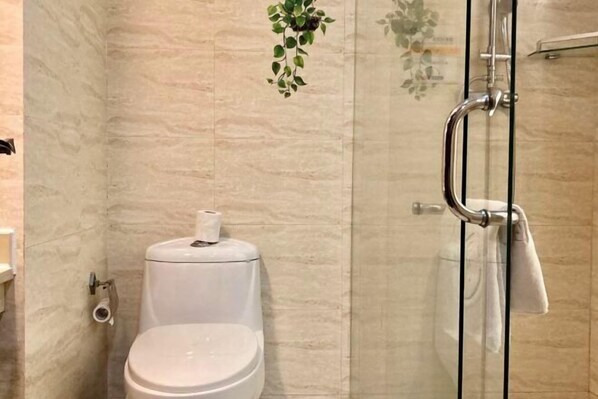 A bathroom with a toilet, a glass shower enclosure, and a towel rack. - Yiting Business Hotel (Quanzhou)