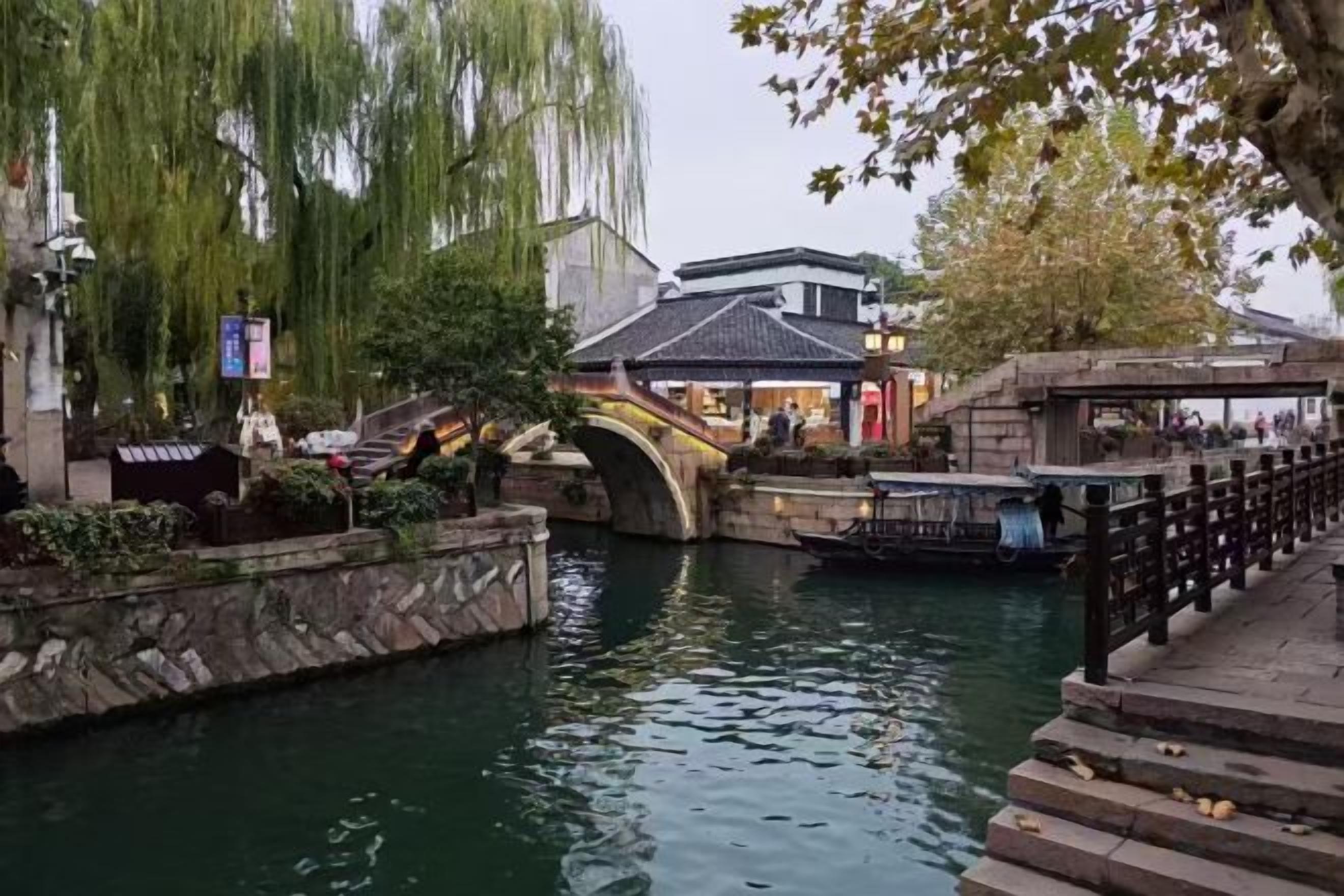 Uma ponte tradicional sobre um canal, com grades de pedra e passarela para pedestres.