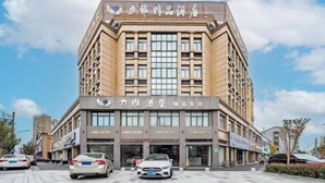 A hotel with multiple LIME HOTEL signs, a large entrance, and a parking area with cars. - Nanxun Liwei Boutique Hotel (Huzhou)