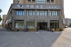 Un HOTEL LIWEI con fachada moderna, múltiples accesos y un área de estacionamiento para motocicletas.