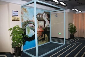 A room with a glass partition, a framed picture, and two potted plants. - Nanxun Liwei Boutique Hotel (Huzhou)