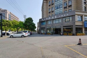 A hotel with a modern facade, multiple units, and a parking area. - Nanxun Liwei Boutique Hotel (Huzhou)