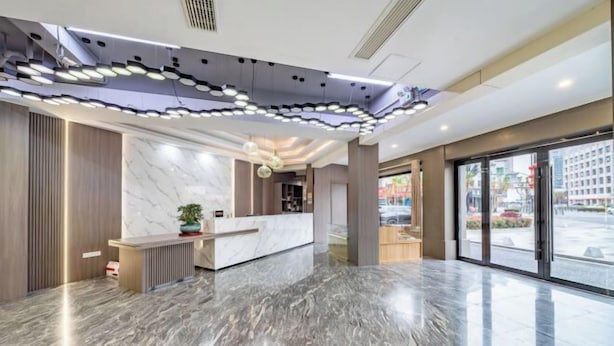A modern reception area with a marble floor, a reception desk, and a large window offering a view of the street. - Nanxun Liwei Boutique Hotel (Huzhou)
