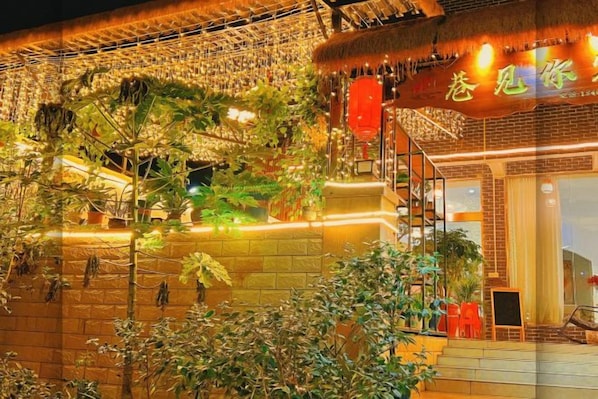 A building with a traditional architectural style, featuring a thatched roof and a staircase leading to an upper level. - Alley See You Inn (Danxia Mountain Scenic Area) (Renhua)