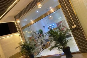 A modern interior with a glass storefront, potted plants, and a neon sign. - Alley See You Inn (Danxia Mountain Scenic Area) (Renhua)