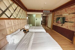 Habitación de hotel con dos camas, un televisor y un espejo.