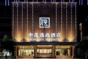 Exterior del hotel Zhongmaoyi Shang, con señalización iluminada y fachada moderna.