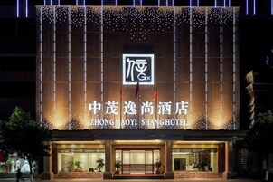 Exterior del hotel Zhongmaoyi Shang, con señalización iluminada y fachada moderna.