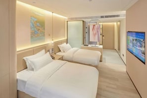 Habitación de hotel con dos camas, un espejo grande, un televisor y obras de arte en las paredes.