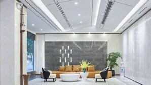 Un vestíbulo moderno con un conjunto de sofás, una mesa de centro y una planta decorativa.
