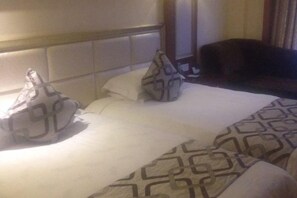 Ein Hotelzimmer mit einem Bett, Kissen und Kopfteil.