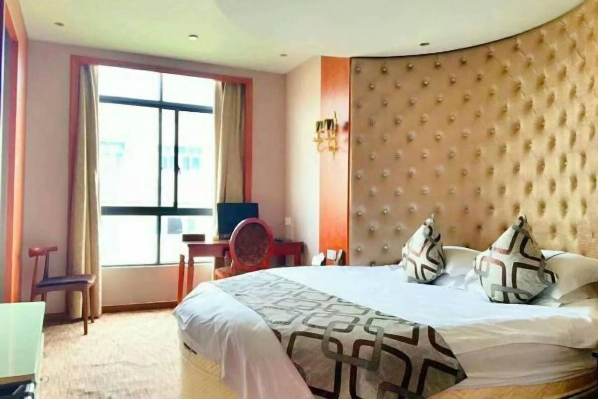 Una habitación de hotel con una cama grande, un escritorio y una silla.