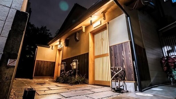 A house with a garage door, a wooden fence, and a stone pathway leading to the entrance.