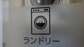 A sign with a washing machine icon and Japanese text.
