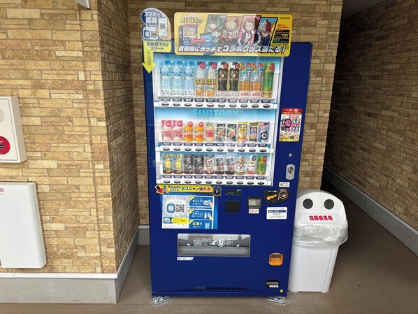 A vending machine with various drinks and snacks, a touch screen interface, and a trash bin. - Family Stay Tsukuba (Tsukuba)