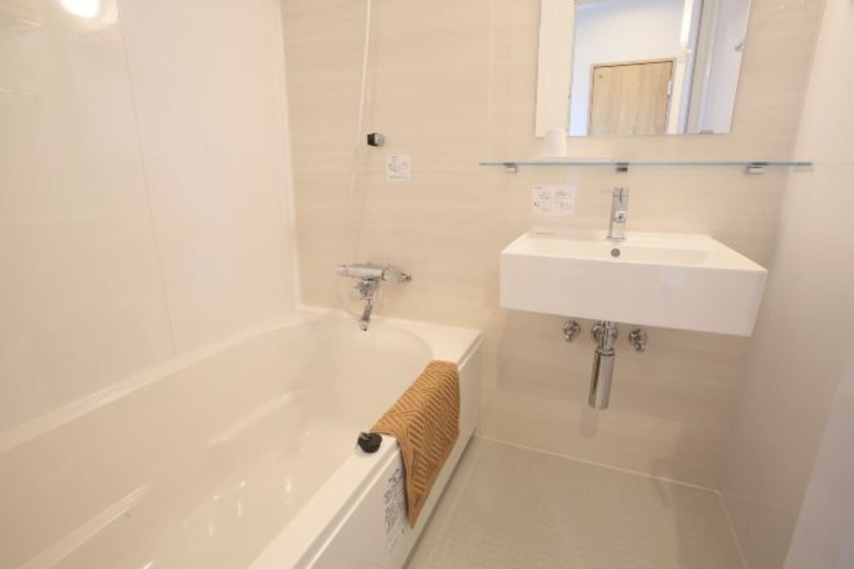 Un baño con bañera, lavamanos y espejo.