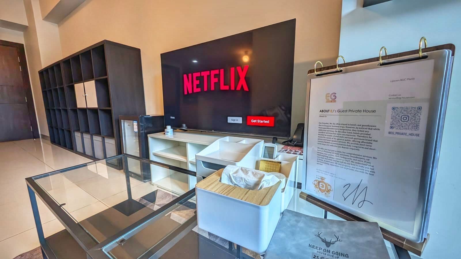 Moderni hotellin aula, jossa on Netflix-logo, vastaanottotiski ja lasiseinä.