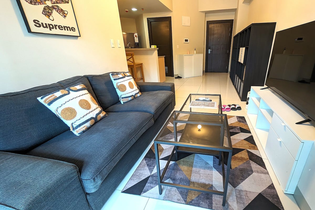 A living room with a sofa, a coffee table, and a TV.