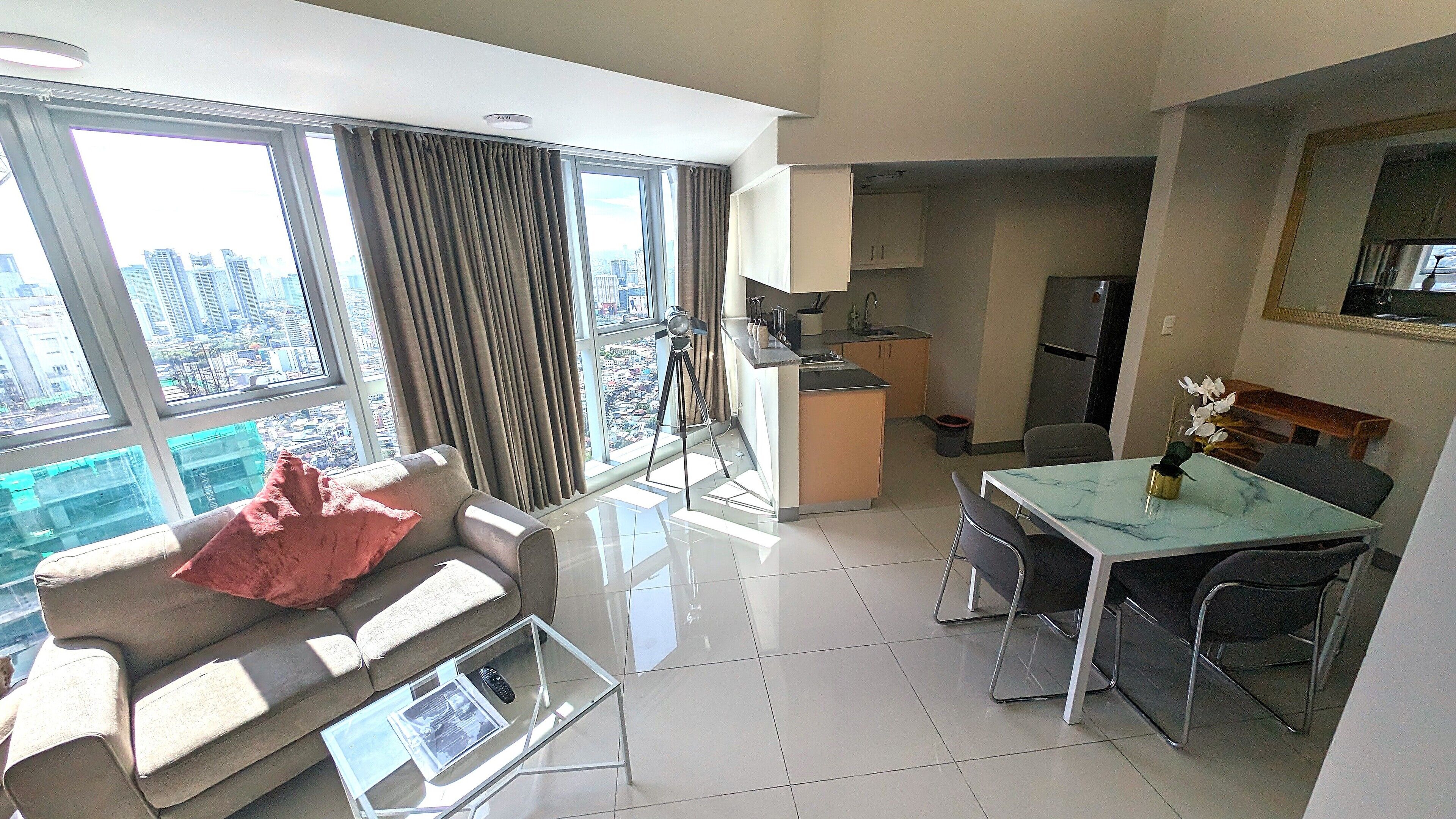 A modern apartment with a living area, kitchen, and dining space.