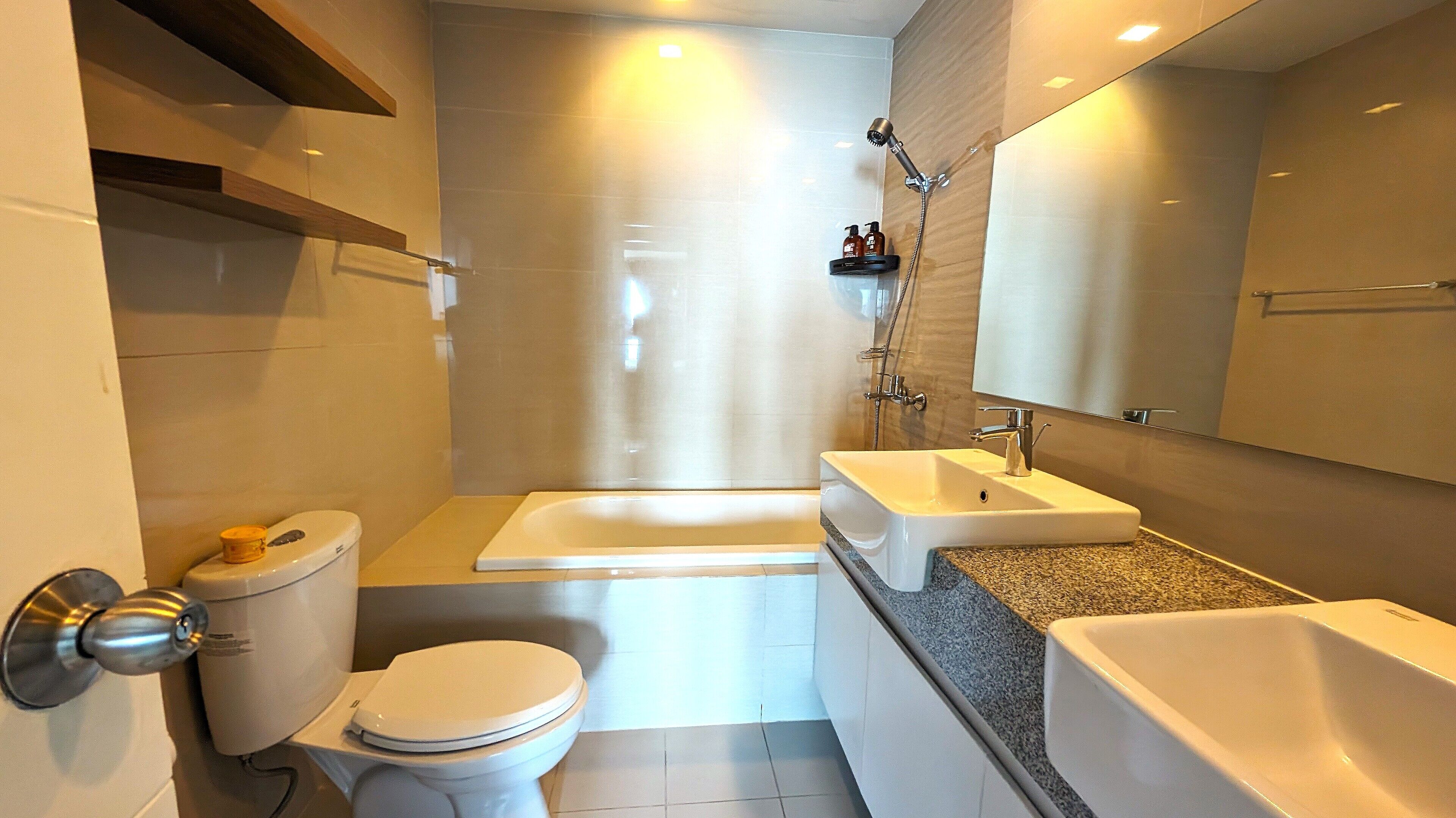 A modern bathroom with a toilet, sink, and bathtub.