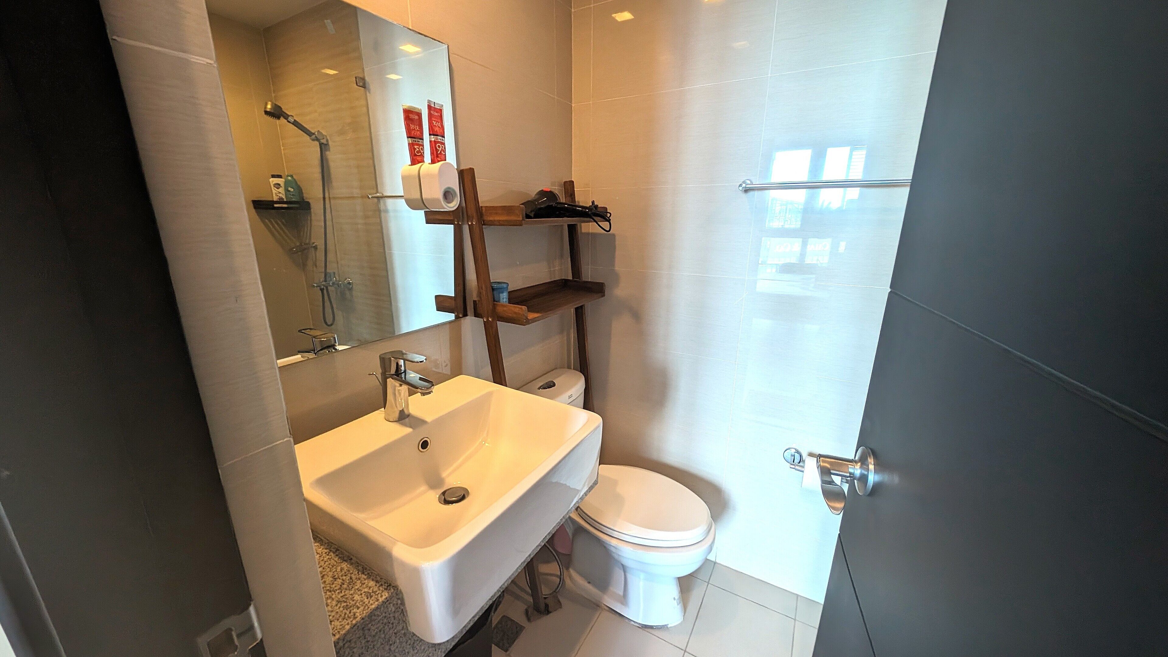 A modern bathroom with a white sink, a toilet, and a shower area.