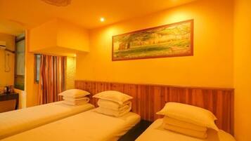 A room with two beds, a wooden headboard, a painting, and a window with curtains.