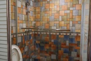 A shower with a glass door, tiled walls, and a metal handrail. - Shipu Xinxing Hotel (Xiangshan)