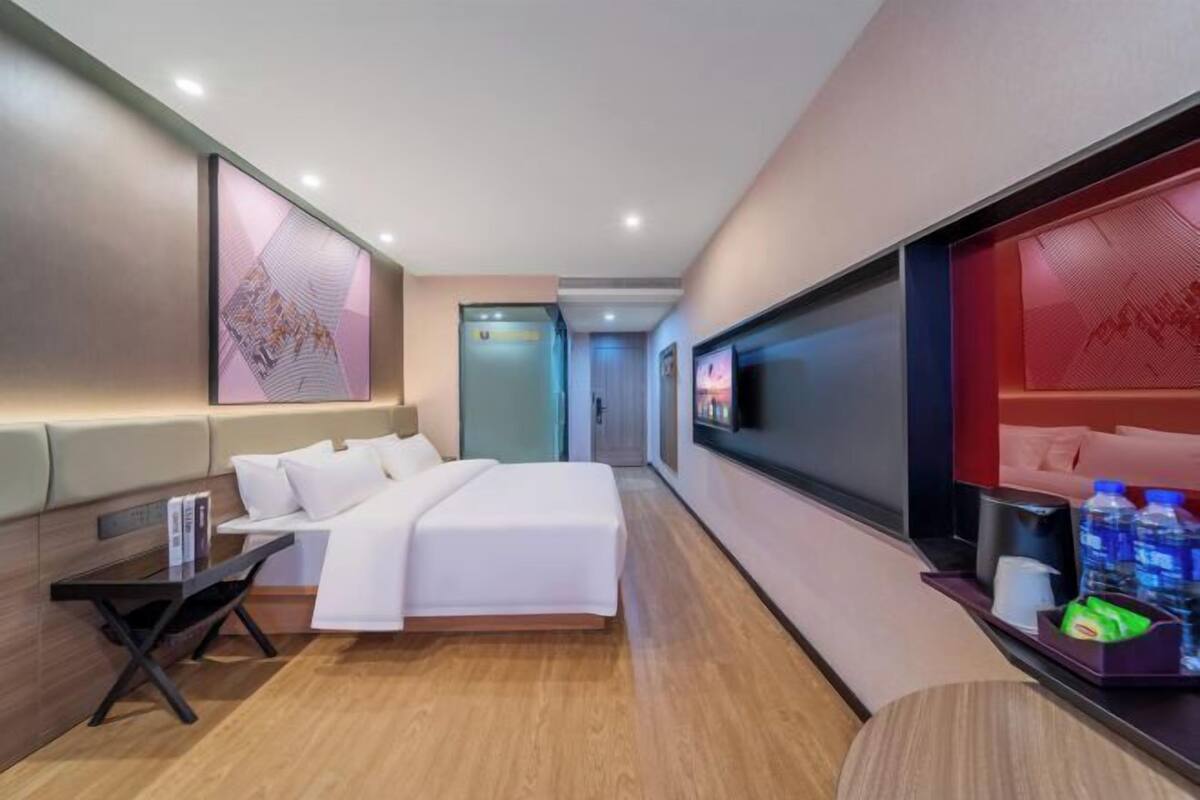 Une chambre d’hôtel avec un lit, une télévision, un bureau et une fenêtre.